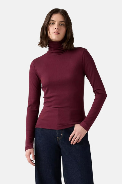 Bordeauxkleurige longsleeve van Levi's, met ribstructuur, gecombineerd met een donkerblauwe jeans.
