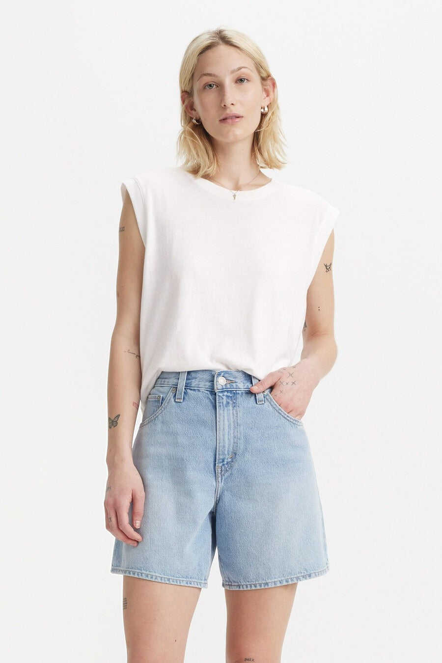 Witte mouwloze top van Levi's, gedragen met denim shorts en een zilveren ketting.