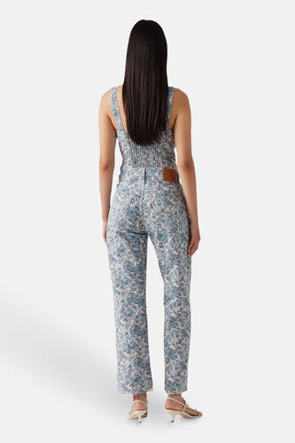Multikleurige rechte jeans van Levi's, met bloemenprint, gecombineerd met een bijpassend topje en beige hakken.
