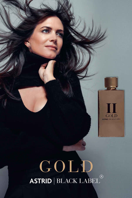 Parfum d'or Astrid Black Label, avec un bouchon doré rayé et un flacon rectangulaire.