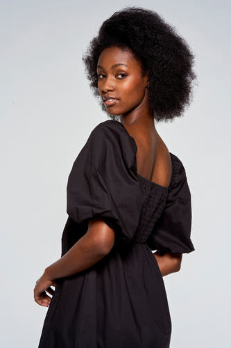 Zwarte jurk met korte mouwen van Astrid Black Label, met pofmouwen en een gerimpelde achterkant.