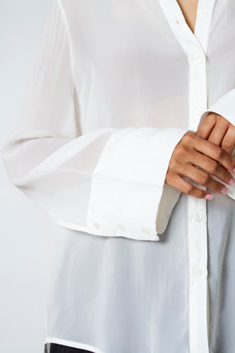 Ecru blouse met lange mouwen van Astrid Black Label, met knoopsluiting en manchetten met knopen.