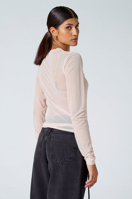 T-shirt à manches longues écru d'Astrid Black Label, tissu transparent avec dos croisé, modèle vu de dos en profil latéral