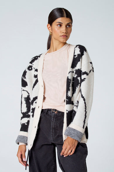 Ecru gilet van Astrid Black Label, met een zwart patroon en gedragen over een lichtroze top en zwarte broek.