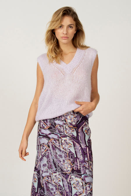 Débardeur noir d'Astrid Black Label, avec un col V et porté sur une longue jupe à imprimé abstrait noir.