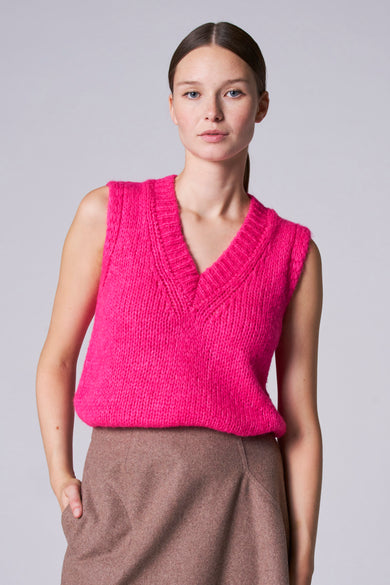 Roze debardeur van Astrid Black Label, met een V-hals en gedragen met een bruine rok.