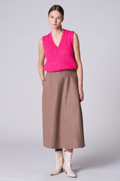 Roze debardeur van Astrid Black Label, met een V-hals en een gebreide textuur, gecombineerd met een bruine rok en beige laarsjes.
