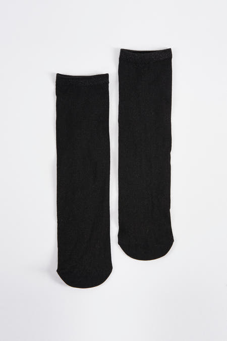 Zwarte sokken van Astrid Black Label, met glitters op de rand, liggend op een witte achtergrond.