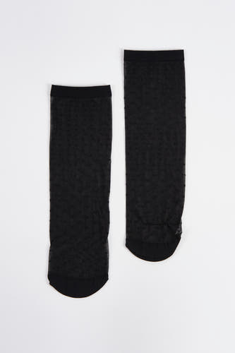 Chaussettes noires d'Astrid Black Label avec des points subtils sur un fond blanc.