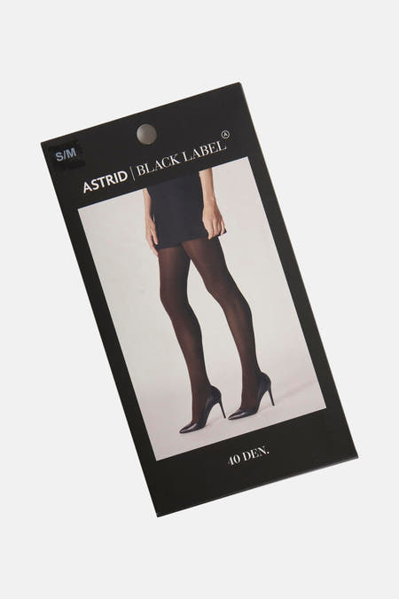 Bruine panty's van Astrid Black Label, getoond op de verpakking met een foto van benen in zwarte pumps en rok.