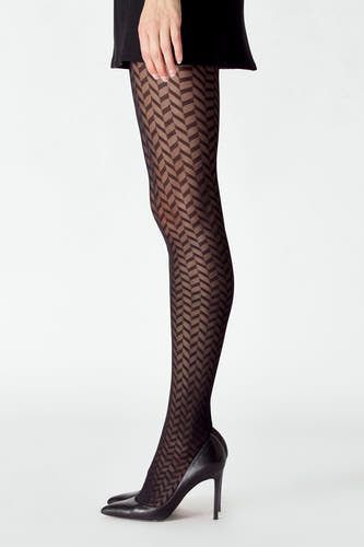 Pantys noirs d'Astrid Black Label, portés avec un motif chevron géométrique et des escarpins noirs et une jupe noire.