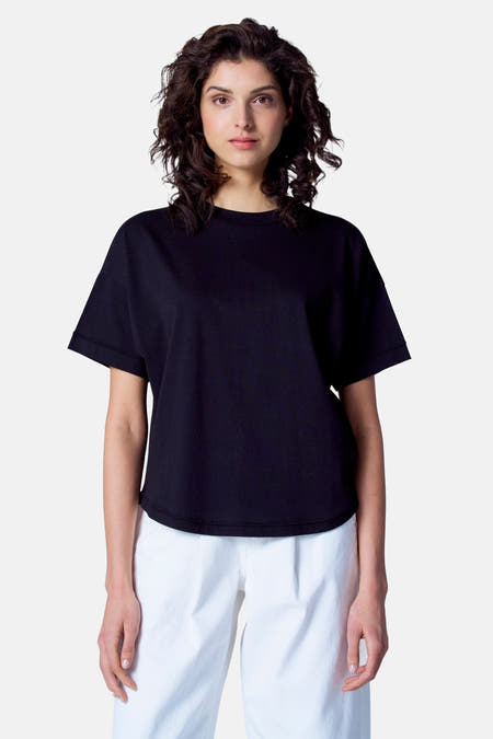 Zwart T-shirt met korte mouwen van Astrid Black Label, gedragen met een witte broek.
