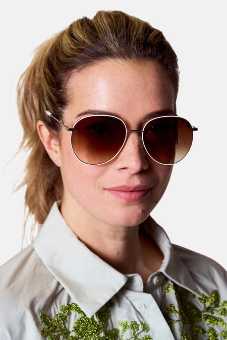 Lunettes de soleil blanches d'Astrid Black Label avec des verres bruns et des détails dorés.