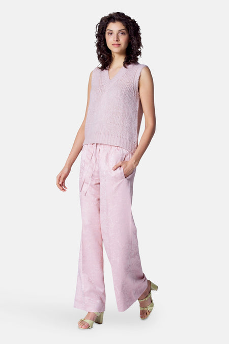 Roze broek van Astrid Black Label met een subtiel bloemmotief en wijde pijpen, gecombineerd met een gebreide top.