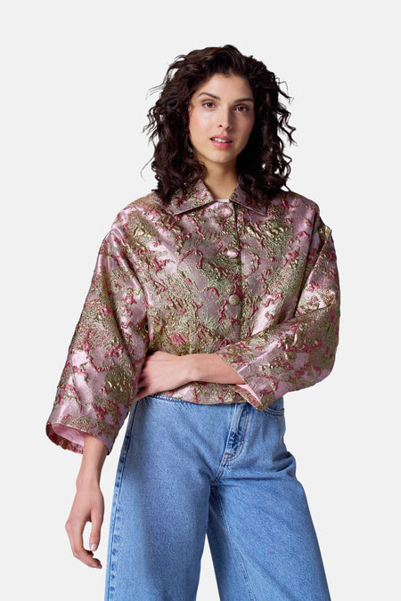 Manteau multicolore d'Astrid Black Label, avec un motif brocart et porté avec un pantalon de jeans large.