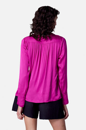 Roze blouse met lange mouwen van Astrid Black Label, met plooien op de rug, gecombineerd met zwarte short.