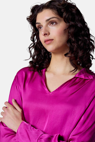 Roze blouse met lange mouwen van Astrid Black Label, met een V-hals en gekruiste armen.