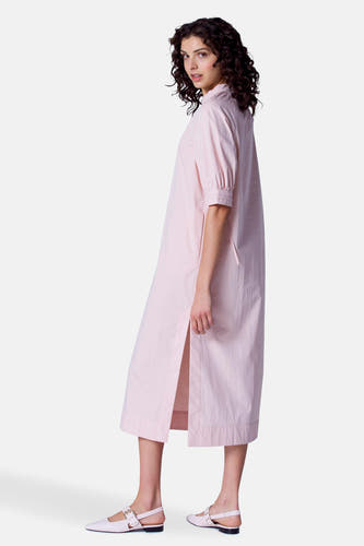 Robe rose à manches courtes d'Astrid Black Label, avec une fente latérale et des ballerinas coordonnées.