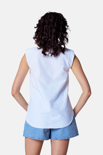 Witte blouse met korte mouwen van Astrid Black Label, gezien vanaf de achterkant, gecombineerd met een denim short.
