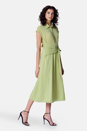 Robe verte avec manches courtes d'Astrid Black Label, à carreaux et ceinture élastique, portée avec des bottes noires.
