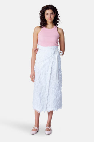 Witte rok van Astrid Black Label, met textuur en wikkeldetail, gedragen met een roze top en roze schoenen.
