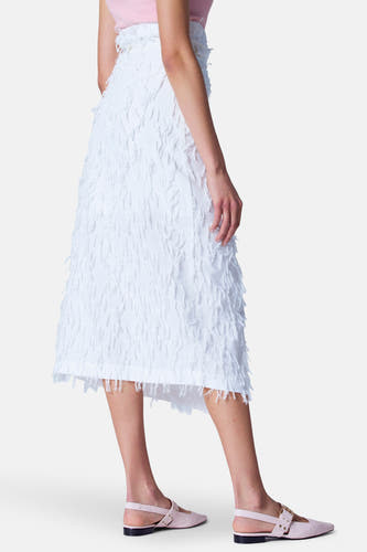 Witte rok van Astrid Black Label, met decoratieve franjes en een asymmetrische zoomlijn, zijwaarts bekeken.