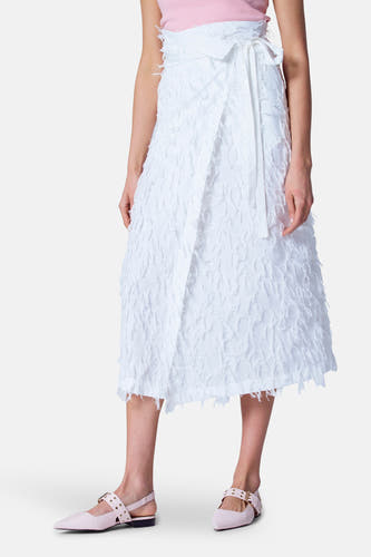 Witte rok van Astrid Black Label, met een overslag en een gerafelde textuur, gecombineerd met roze schoenen.
