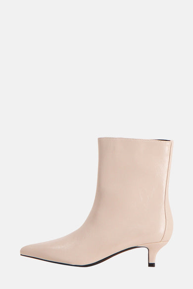 Beige enkellaarsjes van Astrid Black Label, met een spitse neus en een smalle hak in zijaanzicht.

