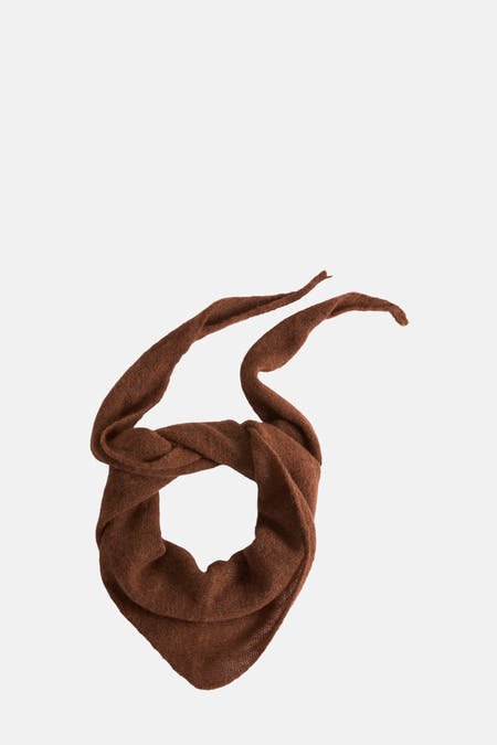 Oranje wintersjaal van Astrid Black Label, gedraaid en geknoopt, met twee losse uiteinden.
