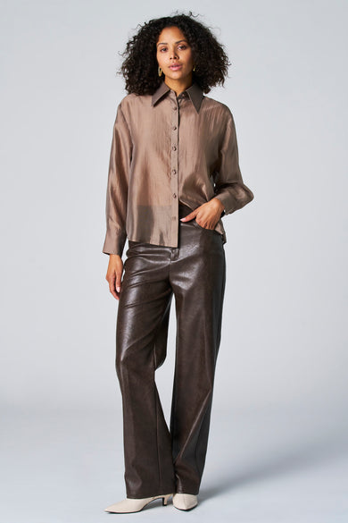 Taupe blouse met lange mouwen van Astrid Black Label, met knoopsluiting en gedragen met leren broek.
