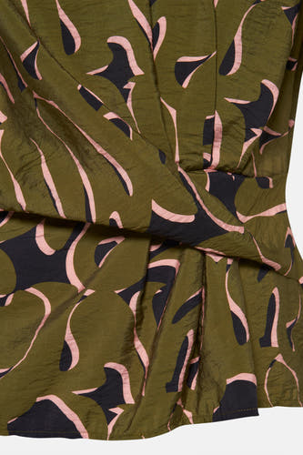 Blouse verte avec manches courtes d'Astrid Black Label, avec des motifs abstraits roses et noirs et des plis.