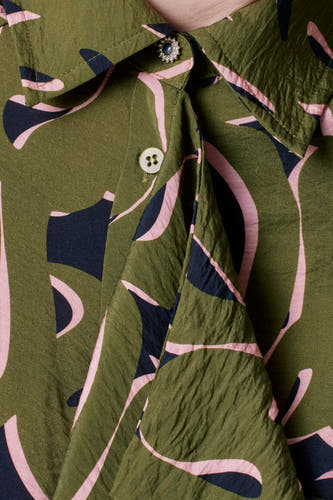 Groene jurk met lange mouwen van Astrid Black Label, met abstract patroon en gekreukte textuur.