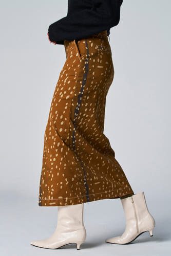Bruine rok met stippenprint van Astrid Black Label, met een verticale baan aan de zijkant en beige laarsjes.
