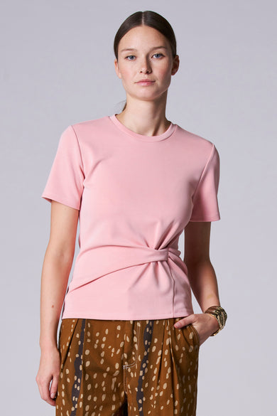 T-shirt rose à manches courtes d'Astrid Black Label, avec un détail de nœud et une jupe imprimée de cerfs.