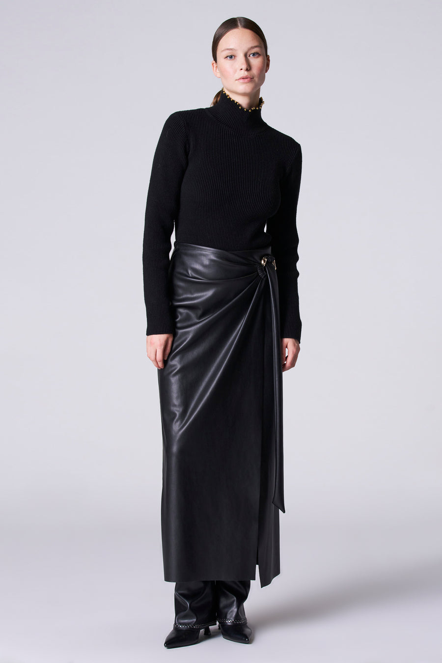 Pull-over noir avec col montant d'Astrid Black Label, doté de détails dorés le la ligne du col.