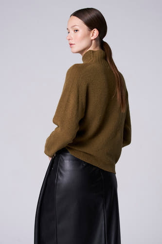 Groene trui met rolkraag van Astrid Black Label, met een zwarte leren rok.