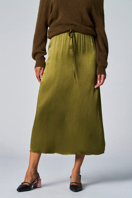 Robe longue verte Astrid Black Label, en tissu brillant et structuré avec une chemise marron.