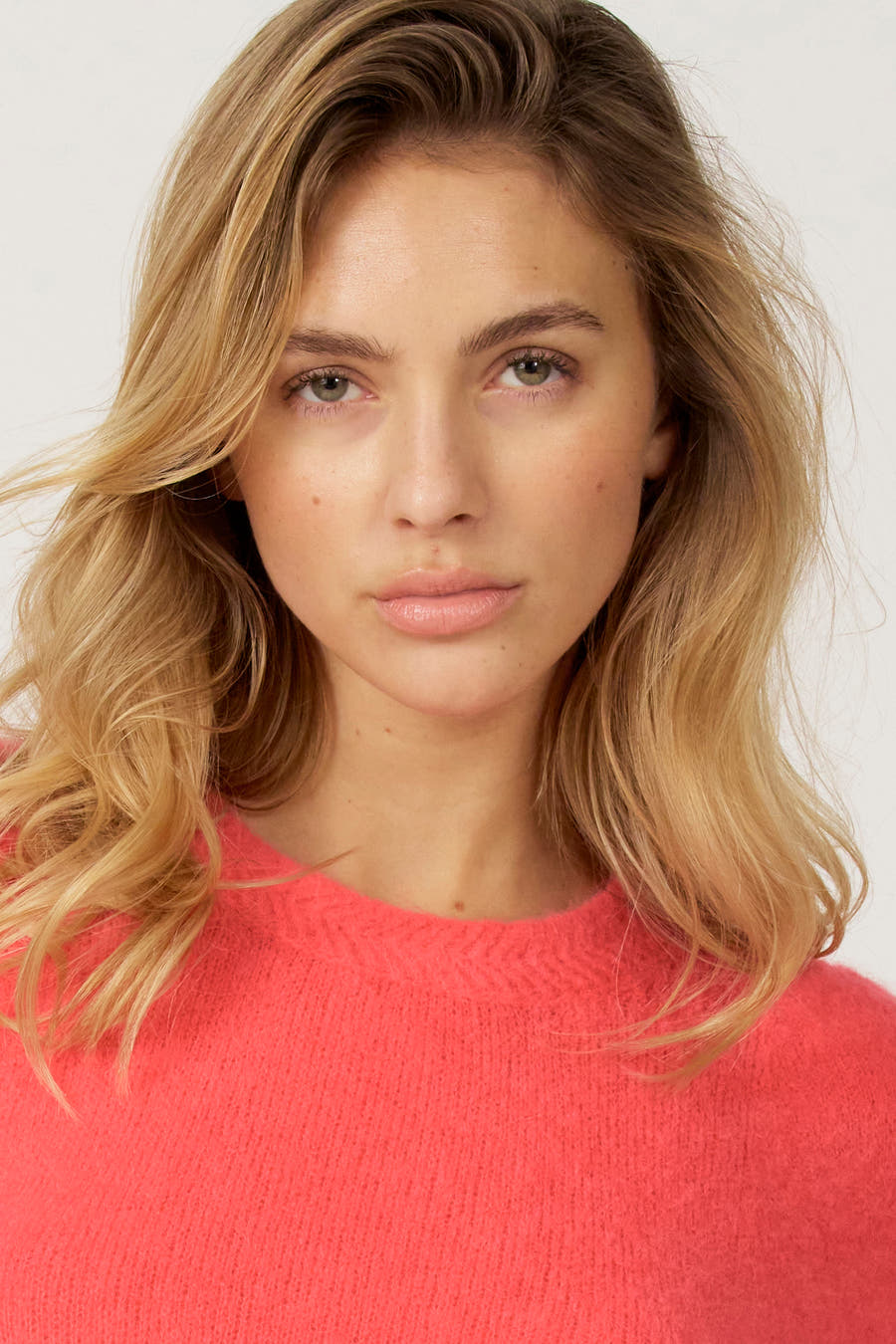 T-shirt rose avec col rond d'Astrid Black Label, en tissu doux et porté par une femme.