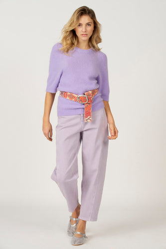 Veste noire avec col rond d'Astrid Black Label, associée à une ceinture colorée et à un pantalon coordonné, portée avec des chaussures brillantes.