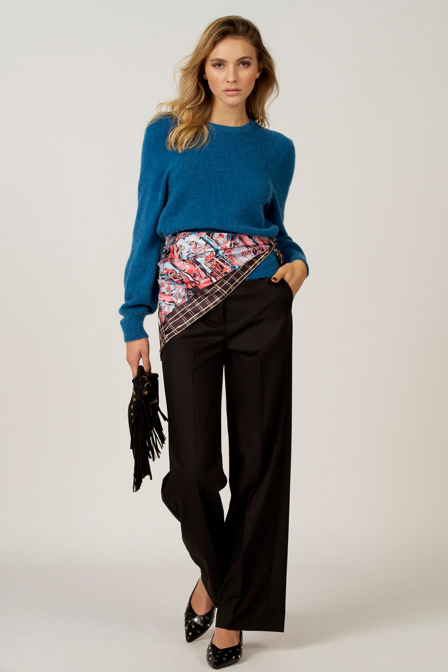 Blauwe trui met ronde hals van Astrid Black Label, gedragen met een sjaal en zwarte pantalon.
