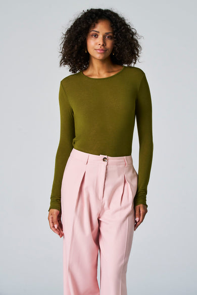 T-shirt vert avec manches longues d'Astrid Black Label, porté avec un pantalon rose.