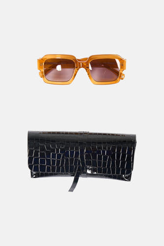 Oranje zonnebril van Astrid Black Label, met een zwarte brillenkoker met krokodillenpatroon.