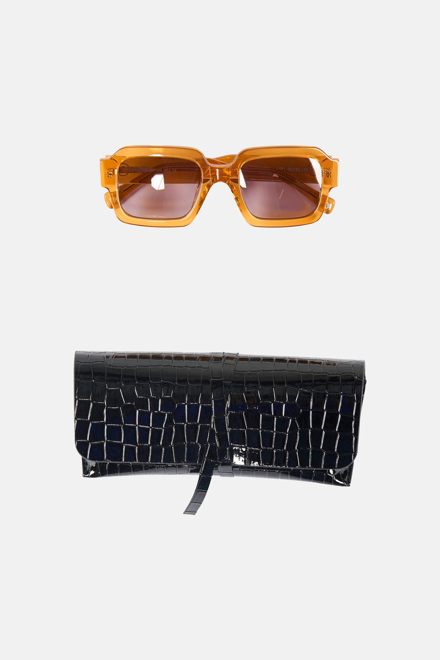 Oranje zonnebril van Astrid Black Label, met een zwarte brillenkoker met krokodillenpatroon.