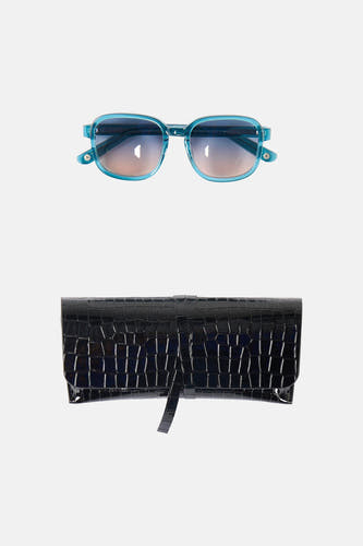 Lunettes de soleil bleues Astrid Black Label, avec des verres dégradés et un étui noir à motif crocodile.