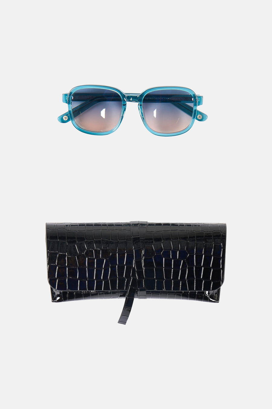 Lunettes de soleil bleues Astrid Black Label, avec des verres dégradés et un étui noir à motif crocodile.