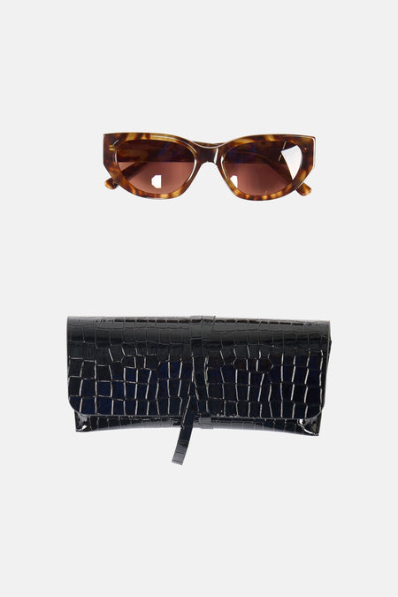 Oranje zonnebril van Astrid Black Label, met een gevlekte montuur en bruine glazen.
