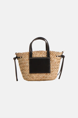 Beige schoudertas van Astrid Black Label met zwarte details en gevlochten textuur.