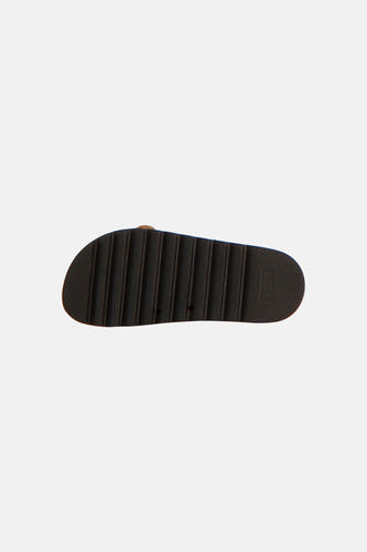 Pantoufles beiges Astrid Black Label avec une semelle épaisse marron foncé et un profil grossier.