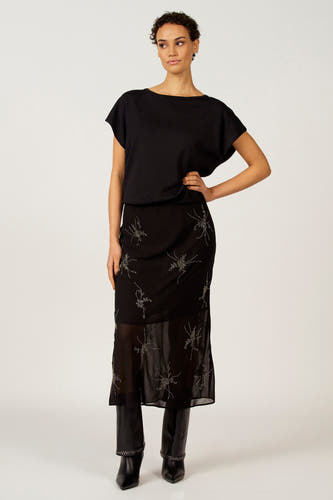 Zwarte rok van Astrid Black Label, met geborduurde bloemmotieven en doorschijnende onderkant.