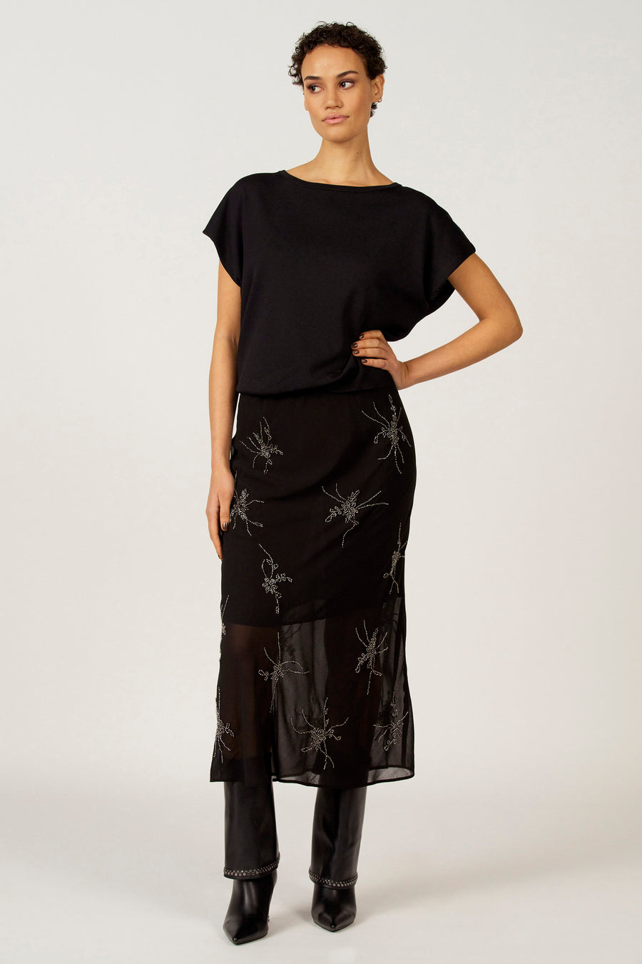 Zwarte rok van Astrid Black Label, met geborduurde bloemmotieven en doorschijnende onderkant.